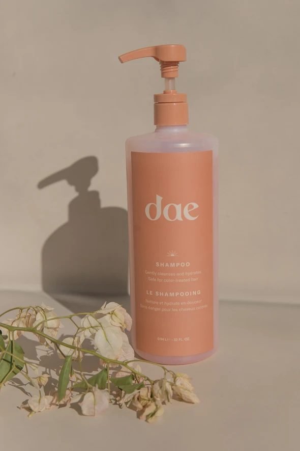 Conditioner bottle on a sand-coloured background