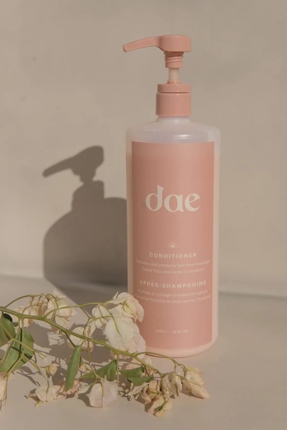 Leave-in conditioner bottle on a sand-coloured background