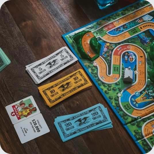 Игрок раздаёт деньги в соревновательной настольной игре