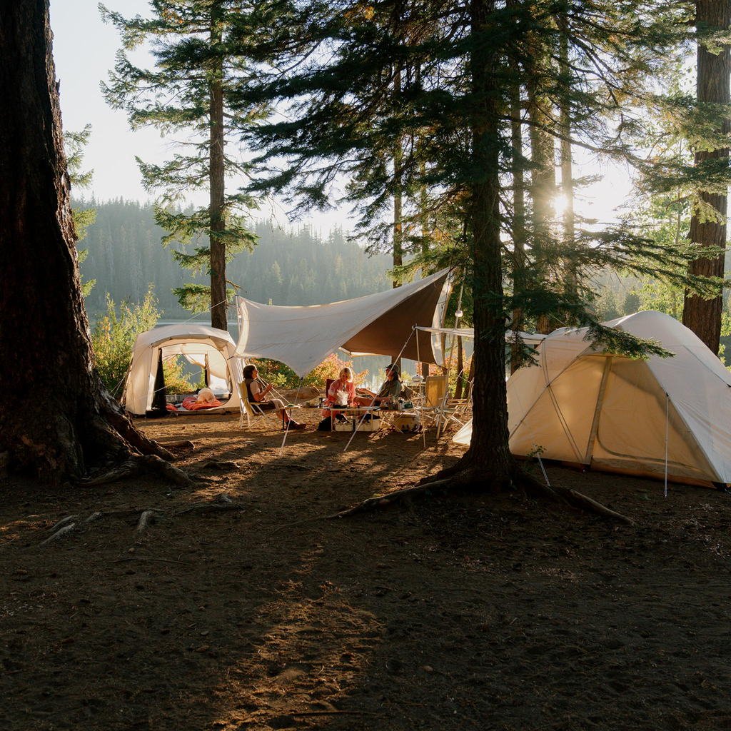 Summer camp set up with several girls sitting around the site.