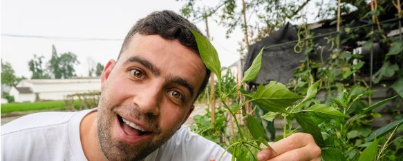 Tom from Yep Kitchen picking a ripe chilli in a Sichuan field