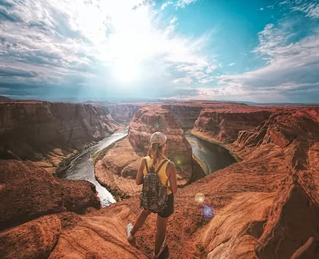 Couple on red rock above the bend of the Colorado River at Horseshoe Bend