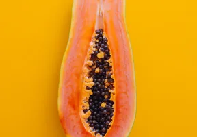 Halved papaya on a yellow background